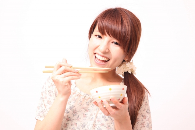 美味しそうにご飯を食べる女性
