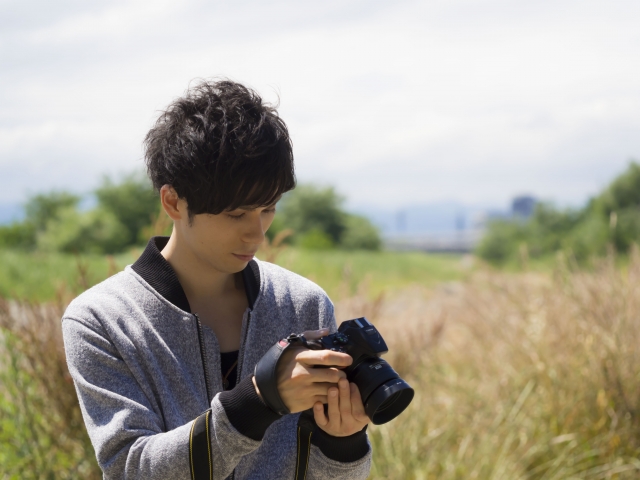 カメラをのぞいている男性