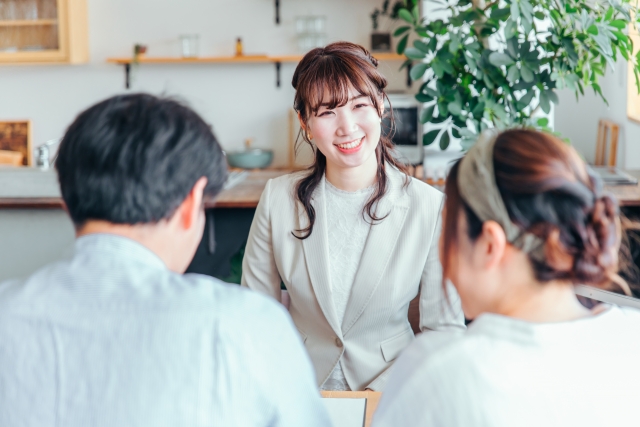 カップルの前で笑顔で話を聞くカウンセラー
